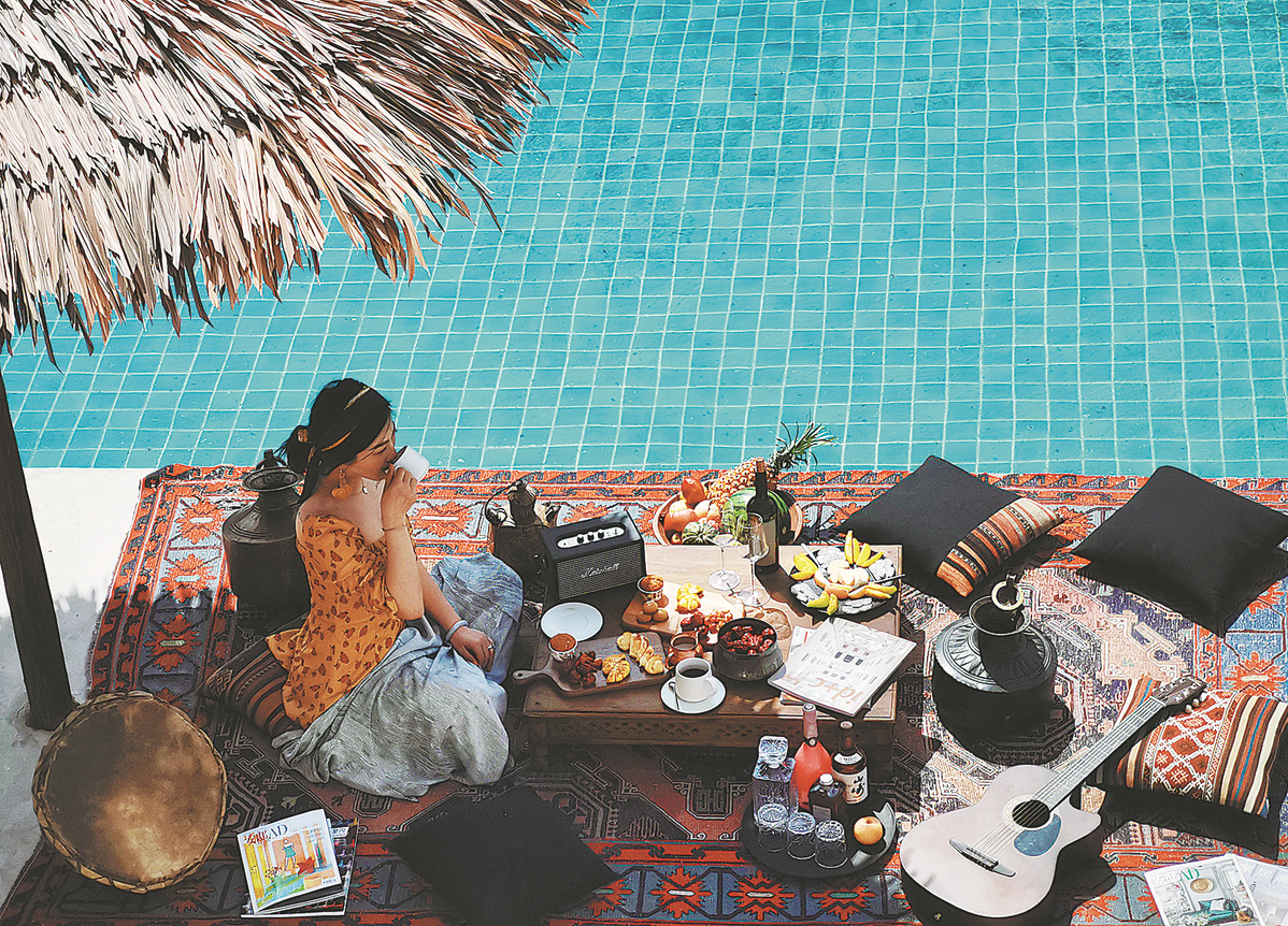 Seorang pelancong menikmati hidangan di tepi kolam renang di inap desa di bandar Zhongwei, Wilayah Autonomi Hui Ningxia, China. (foto: China Daily)