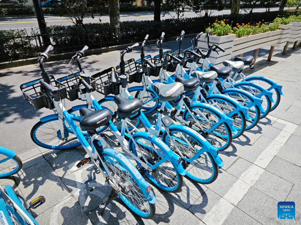 Foto bertarikh 22 Julai 2024 ini memaparkan beberapa buah basikal kongsi yang memakai ‘kot kalis matahari’ disamping basikal lain di Hangzhou, provinsi Zhejiang, timur China. (Xinhua/Lin Guangyao)