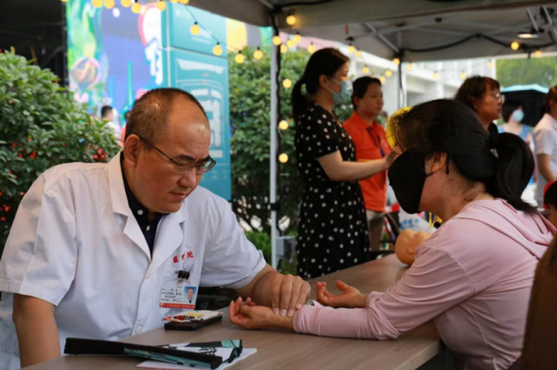 Pakar TCM dari Hospital TCM Provinsi Shandong membuat diagnosis nadi untuk penduduk tempatan di pasar malam TCM. (Gambar ihsan Hospital TCM Provinsi Shandong)