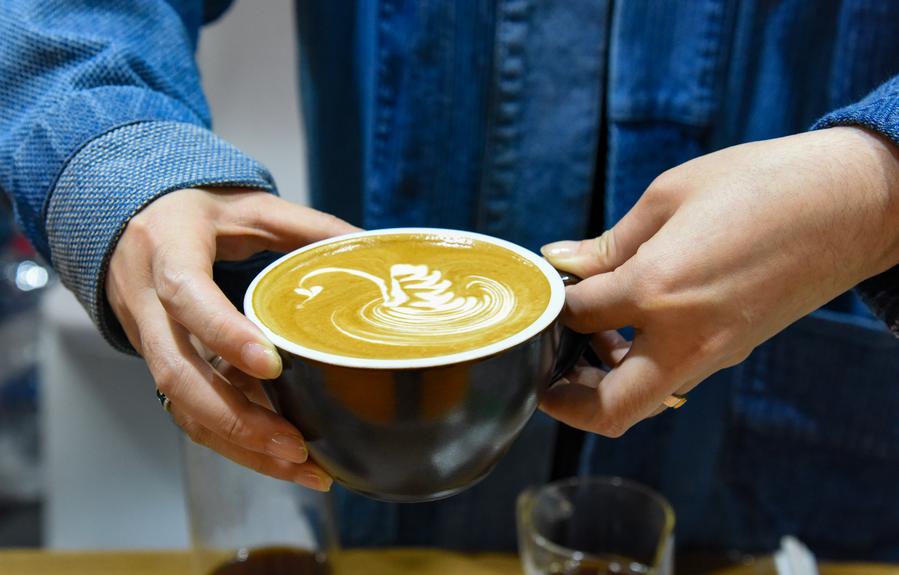 Seorang pempamer menunjukkan secawan kopi berseni semasa Ekspo Kopi Antarabangsa (Pu’er) China di Provinsi Yunnan pada 5 Januari 2024. (Xinhua/Xiong Xuanang)