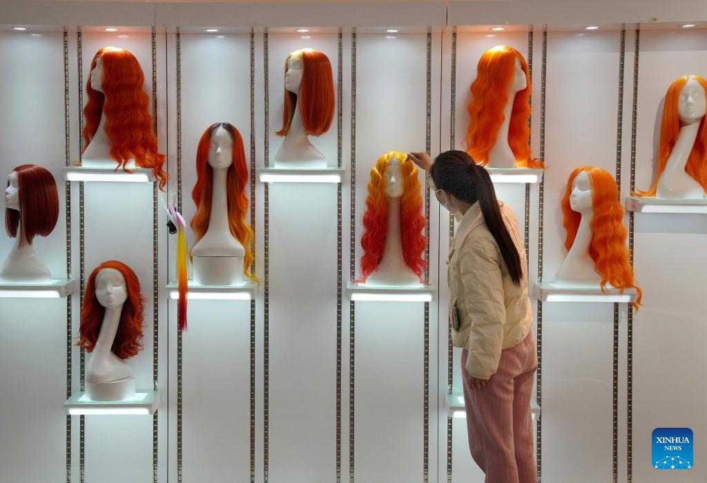 Seorang pelanggan memilih rambut palsu di bilik pameran Henan Rebecca Hair Products di Xuchang, provinsi Henan, tengah China, 16 Mac 2023. (Xinhua/Li An)