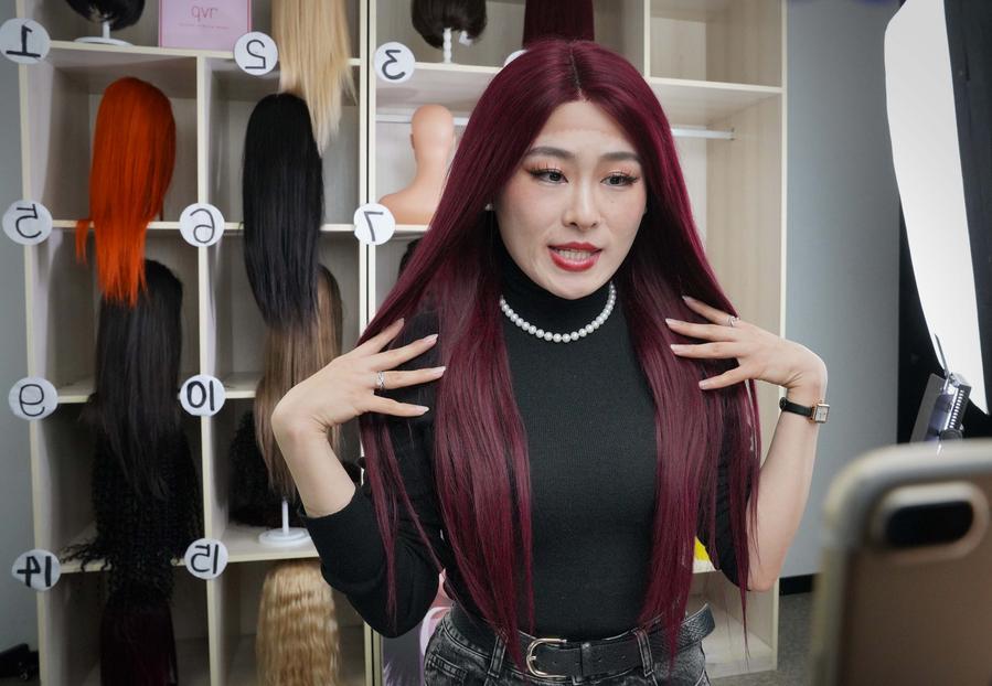 Seorang pekerja Henan Rebecca Hair Products memperkenalkan produk menerusi strim langsung di Xuchang, provinsi Henan, tengah China, 16 Mac 2023. (Xinhua/Li An)