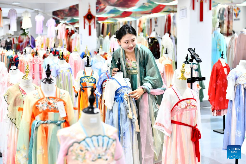 Seorang wanita menjual Hanfu melalui penstriman langsung di Perbandaran Ancailou di Kaunti Caoxian, Provinsi Shandong, timur China, 6 Julai 2023. (Xinhua/Guo Xulei)