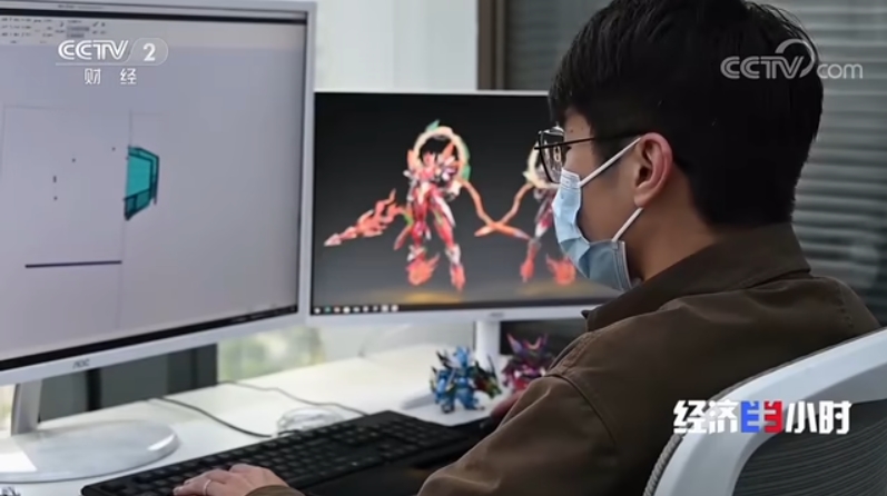 Foto seorang petugas di Syarikat Dongxiu Cultural Communication yang sedang mereka bentuk mainan seni. (Tangkap layar daripada laporan CCTV)