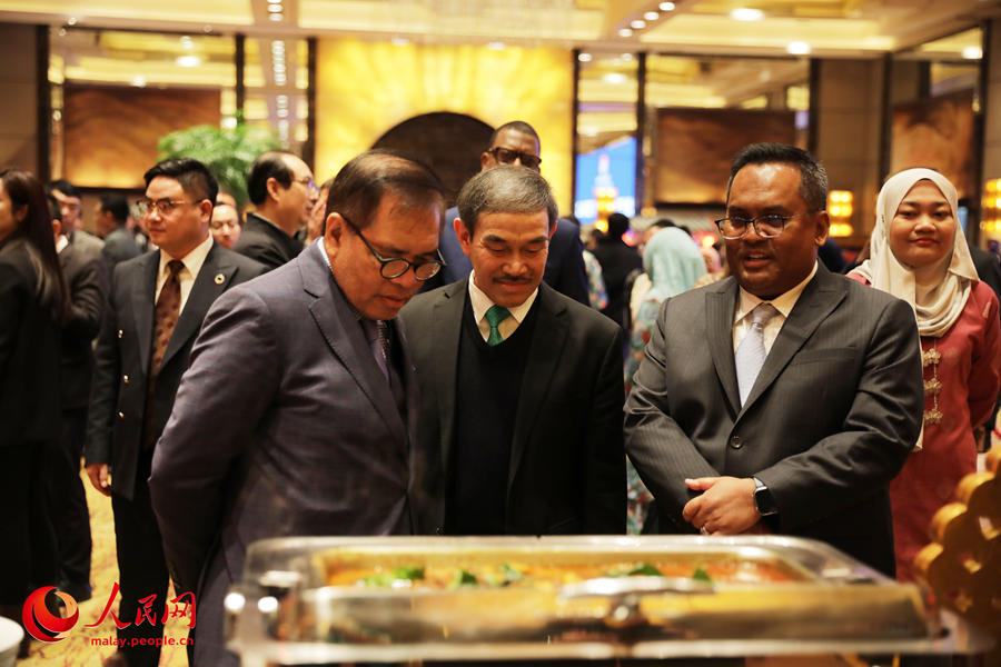 Datuk Norman Muhamad (paling kanan) sedang memperkenalkan sajian hidangan Malaysia kepada Duta Besar Brunei ke China (tengah) dan Duta Besar Indonesia ke China (paling kiri) program Festival Gastronomi Malaysia di Beijing, ibu negara China, pada Selasa. (Wang Jing/People’s Daily Online)