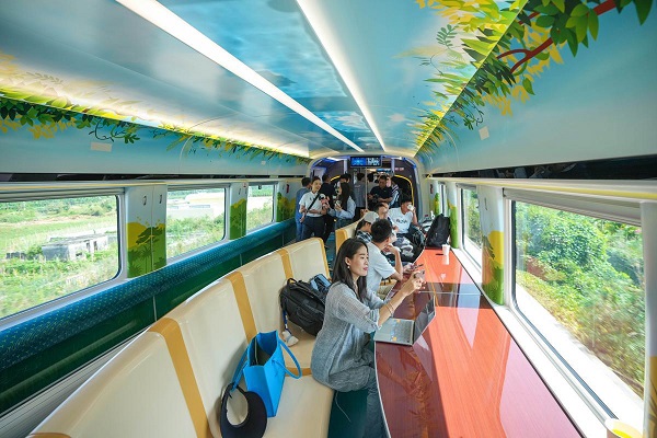 Penumpang sedang menikmati pemandangan menerusi tingkap pada tingkap kereta api pelancong Sanya-Ledong (Foto Wang Chenglong/China Daily)