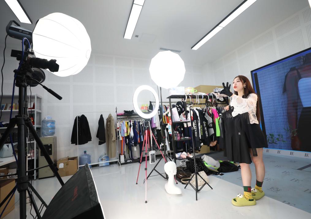 Seorang jurujual membuat sesi siaran langsung untuk menjual pakaian renang di sebuah syarikat pakaian renang di Huludao, Provinsi Liaoning timur laut China, pada 18 April 2024. (Xinhua/Yang Qing)