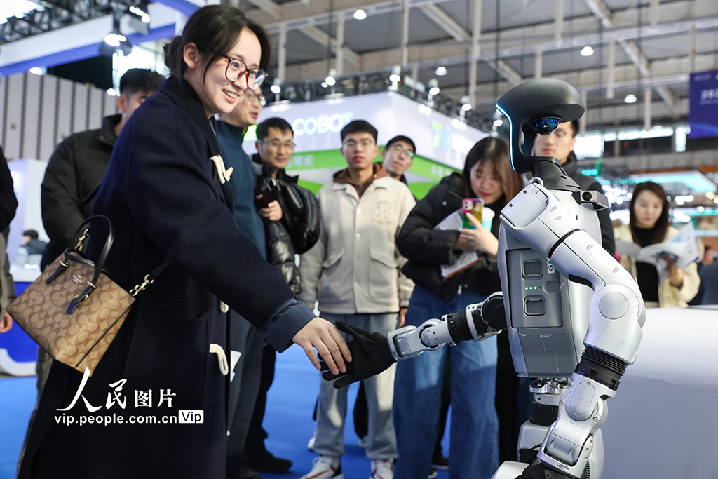 Seorang peserta sedang berinteraksi dengan robot semasa Persidangan Pembuatan Pintar Dunia 2024 yang membuka tirainya di Pusat Ekspo Antarabangsa Nanjing, Provinsi Jiangsu, timur China pada 20 Disember 2024. (Foto/Su Yang)