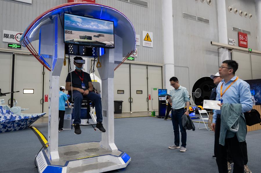 Seorang pelawat sedang mencuba payung terjun realiti maya (VR) di sebuah pameran aeroangkasa di Wuhan, Provinsi Hubei, tengah China pada 23 April 2024. (Xinhua/Hu Jingwen)