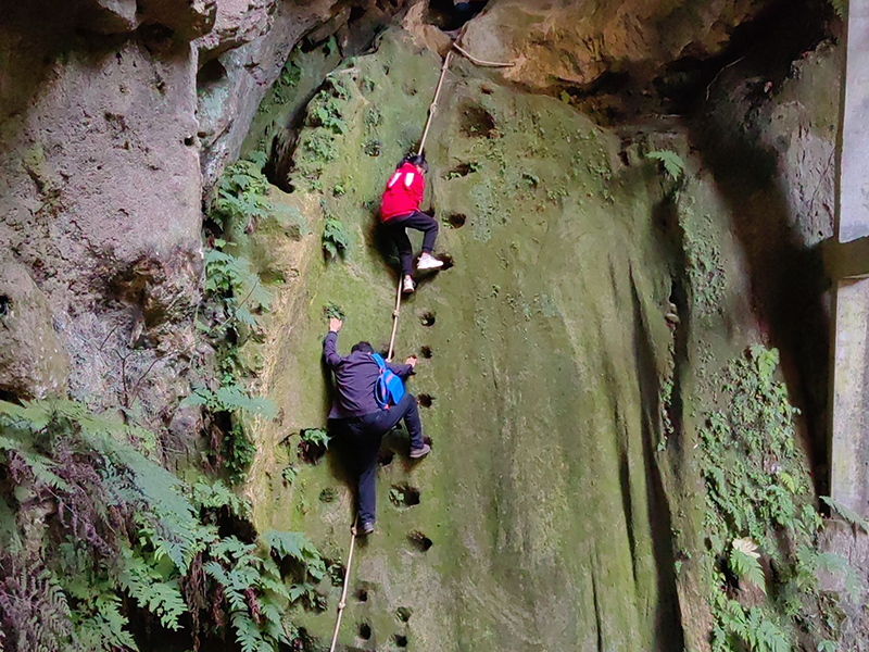 Seorang dewasa menemani seorang kanak-kanak perempuan memanjat tebing untuk ke sekolah. (Foto fail)