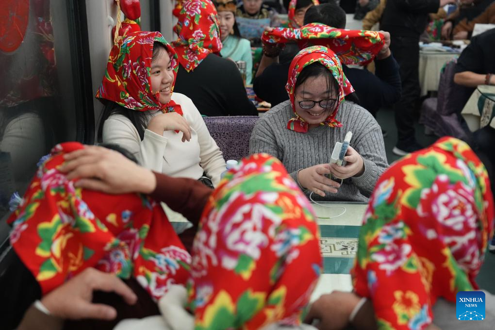 Foto penumpang sedang menonton persembahan. (Xinhua/Wang Song)