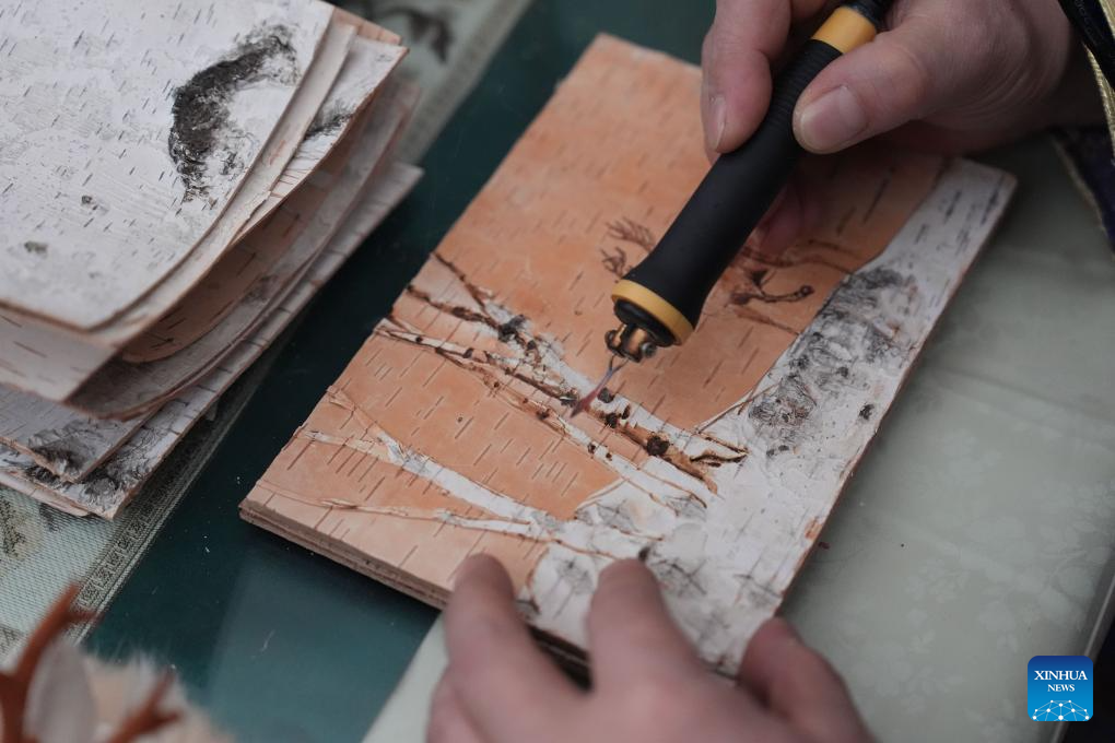 Du Hui, pewaris teknik pembuatan sulaman jarum api kulit kayu birch sedang menghasilkan satu seni tradisional tersebut. (Xinhua/Wang Song)
