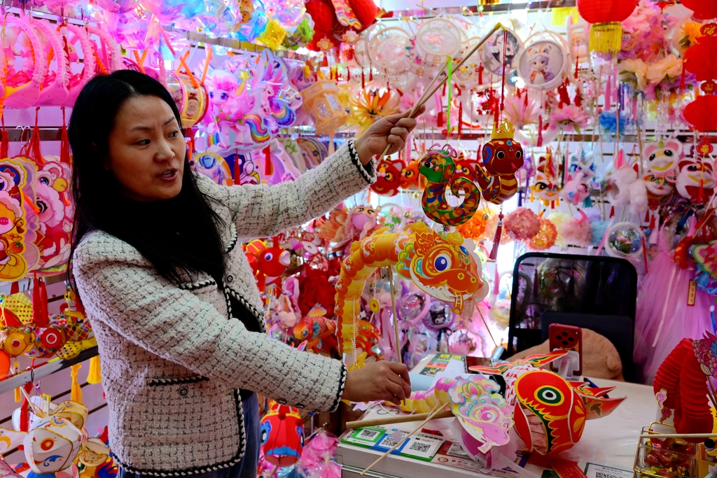 Peniaga mempamerkan tanglung bertemakan Tahun Ular di kawasan dagangan produk kraf perayaan Pasar Perdagangan Antarabangsa Yiwu, provinsi Zhejiang, 28 Disember 2024. (Foto/IC)