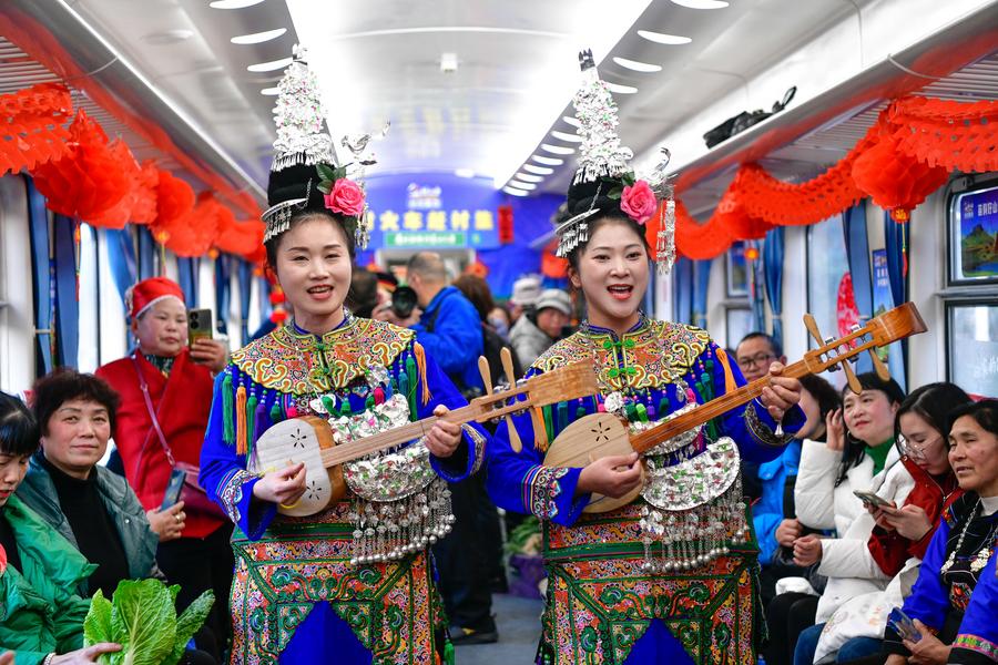 Artis etnik minoriti membuat sedang membuat persembahan di dalam kereta api. (Xinuha/Yang Wenbin)