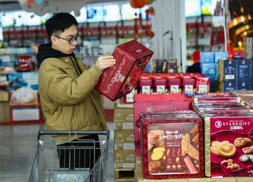 Seorang lelaki membeli-belah di kedai yang menjual komoditi import di Zon Berikat Komprehensif Jinyi di Jinhua, Provinsi Zhejiang, timur China, 11 Januari 2025. (People's Daily Online/Shi Kuanbing)