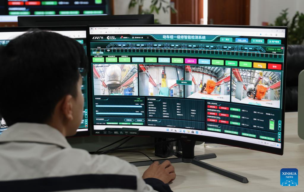 Seorang pegawai penyelenggara memeriksa kereta api tidur laju dari jarak jauh menggunakan robot pintar bawah gerabak.