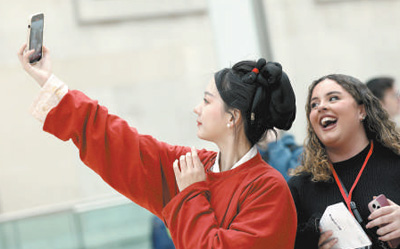 Seorang pelawat bergambar dengan seorang wanita yang memakai Hanfu, pakaian tradisional etnik Han di China, di Muzium British di UK. (Xinhua/Li Ying)