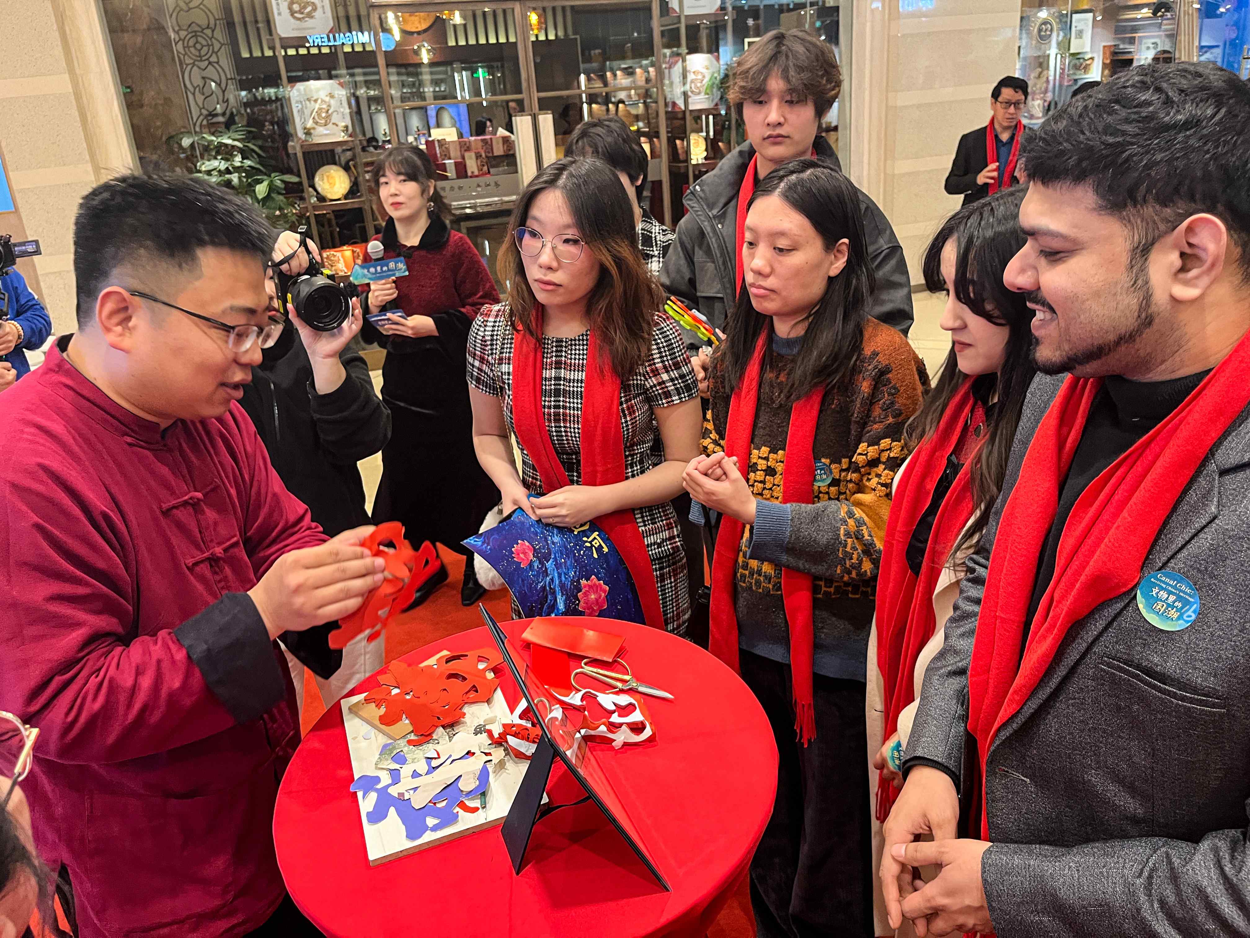 Gao Yang, wakil pewaris pemotongan kertas Yuxian di Provinsi Hebei, utara China, menjemput tetamu untuk merasai pengalaman seni memotong kertas di Beijing pada 22 Januari 2025. (Xian Jiangnan)