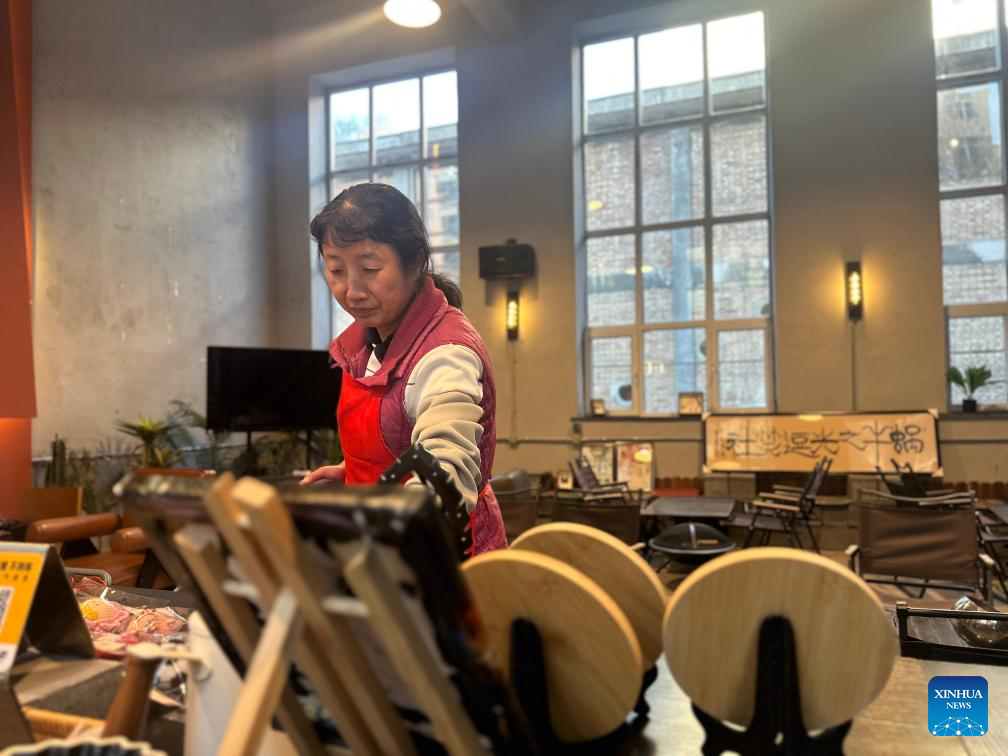 Seorang pekerja kategori Orang Kurang Upaya (OKU) mental sedang bertugas di sebuah kafe yang terletak di Xining, Provinsi Qinghai, barat laut China pada 27 November 2024. (Xinhua/Zheng Ziqi)