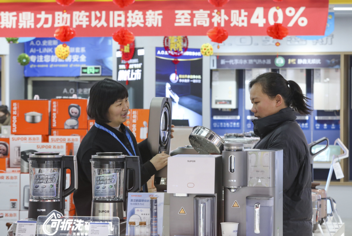 Seorang pembeli (kanan) sedang memerhatikan peralatan memasak di sebuah kedai di Huaian, Provinsi Jiangsu, pada 31 Januari. (Zhao Qirui/China Daily)