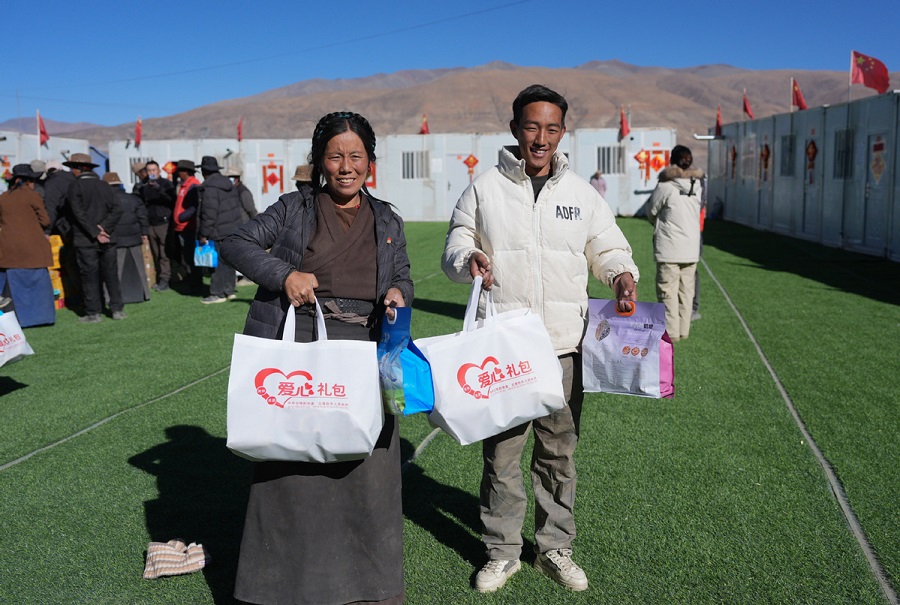 Foto orang ramai menerima bungkusan makanan di tapak penempatan semula di kampung Gyabgag, kaunti Lnaze, Wilayah Autonomi Xizang, pada 27 Januari 2025. (Xinhua)