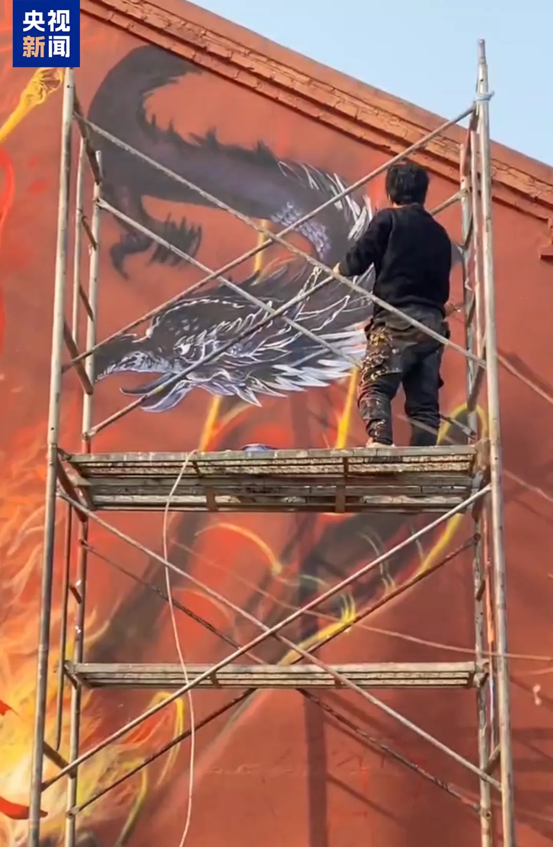 Shen Jingyu sedang menghasilkan mural gergasi yang menampilkan blokbuster animasi China, ‘Ne Zha 2’ di sebuah dinding di kampung Shenjiacun. (Foto oleh CCTV News)