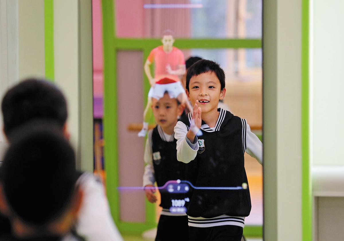 Foto kanak-kanak sedang mengikuti panduan senaman daripada paparan AI di sebuah sekolah rendah di Beijing pada 21 November. (China Daily/Chen Jian)