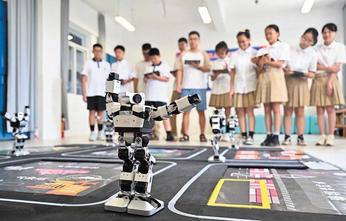 Pelajar sekolah menengah sedang mengoperasikan robot semasa kelas sains di Liuzhou, Wilayah Autonomi Guangxi Zhuang pada September. (Xinhua/Li Hanchi)