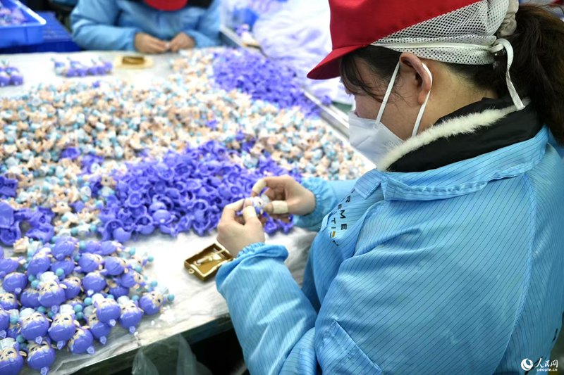 Pekerja sedang sibuk menghasilkan patung figura bertemakan Ne Zha. (People’s Daily Online/Liu Shan)