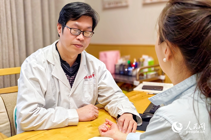 Seorang doktor perubatan tradisional Cina memeriksa denyutan nadi pesakit di pusat TCM di daerah Xixia, bandar Nanyang, di Provinsi Henan. (People’s Daily Online/Cheng Minghui)