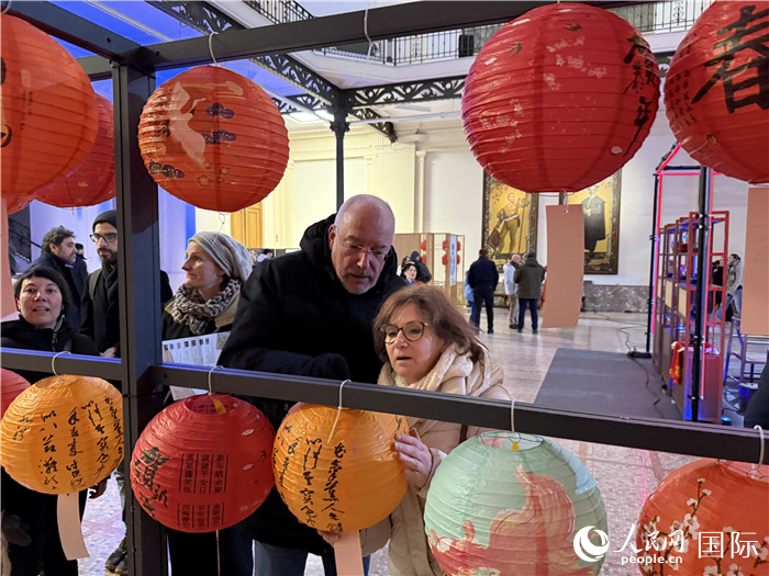 Foto bertarikh 13 Februari 2025 ini memerlihatkan pengunjung sedang meneka teka-teki tanglung dalam satu aktiviti anjuran Misi China ke Kesatuan Eropah di Brussels, Belgium. (People’s Daily Online/Niu Ruifei)