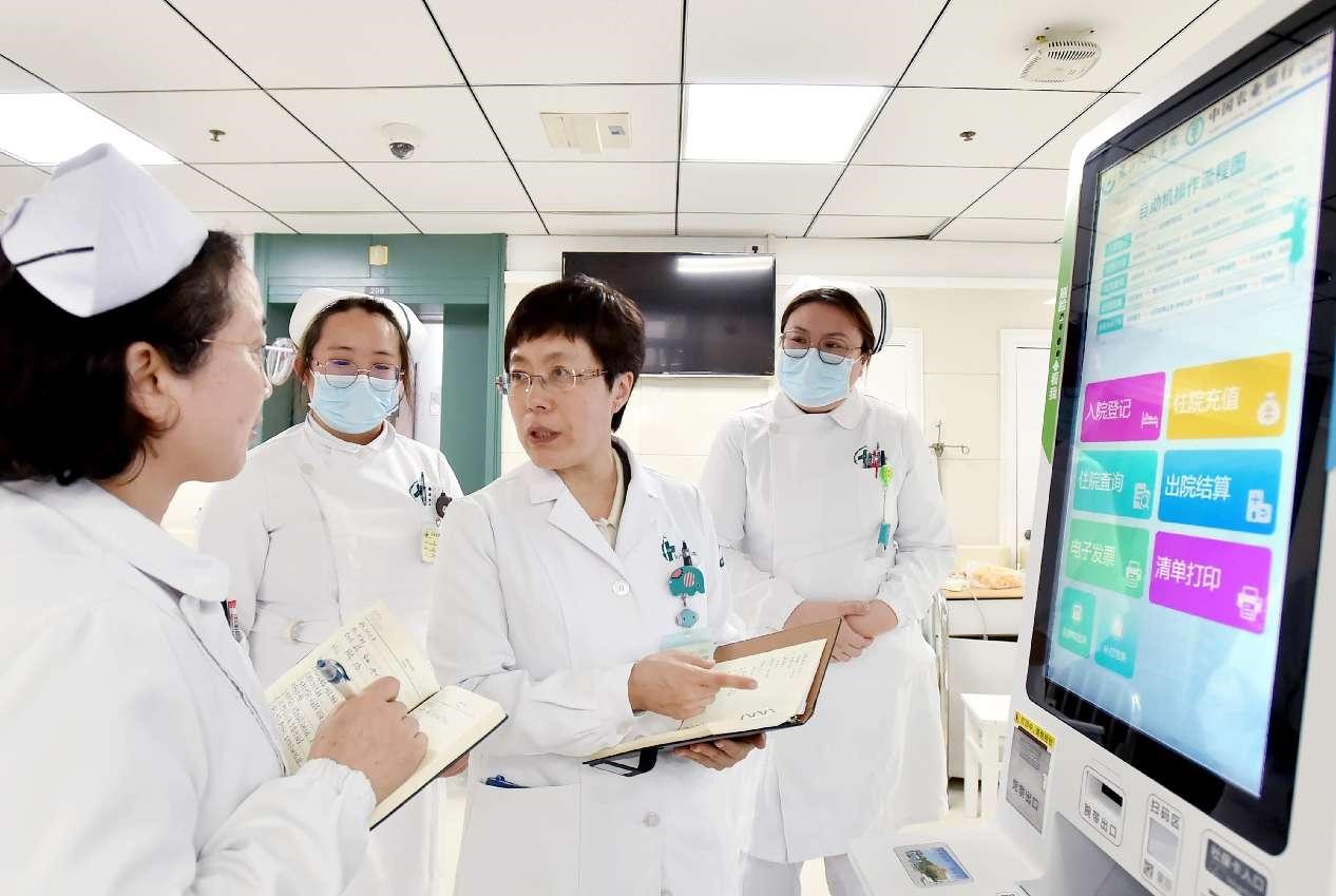 Wei Hua (tiga dari kiri), yang merupakan ahli majlis perundangan NPC dan ketua jabatan perubatan dalaman di Hospital Rakyat Jiangsu Timur di Yangzhou, Provinsi Jiangsu sedang berbincang tentang penambahbaikan penjagaan pesakit dengan jururawat yang bertugas pada 1 Mac 2025. (People’s Daily Online/Zhuang Wenbin)