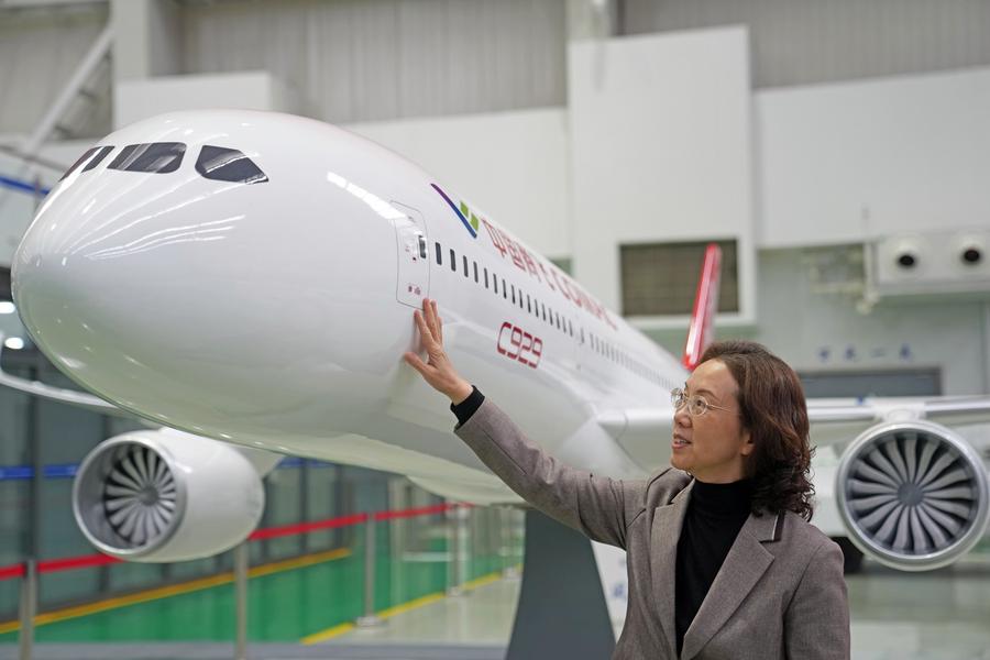 Foto Zhao Chunling sedang memegang model pesawat C929 di institut penyelidikan Perbadanan Pesawat Komersial China (COMAC) di Shanghai, timur China pada 5 Mac 2025. (Xinhua/Liu Ying)