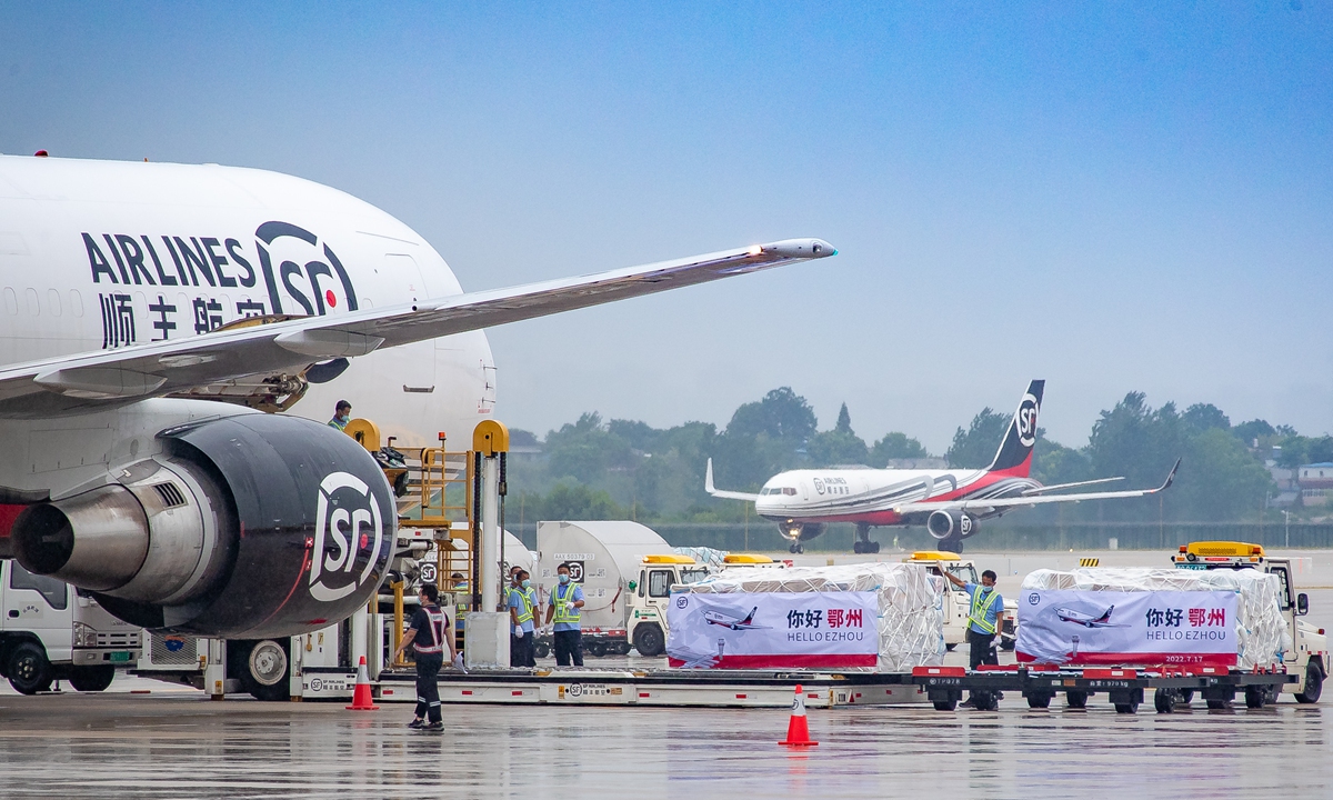 Kru di lapangan terbang mengeluarkan kargo daripada pesawat kargo di Lapangan Terbang Antarabangsa Huahu Ezhou di Provinsi Hubei, tengah China pada 17 Julai 2022.