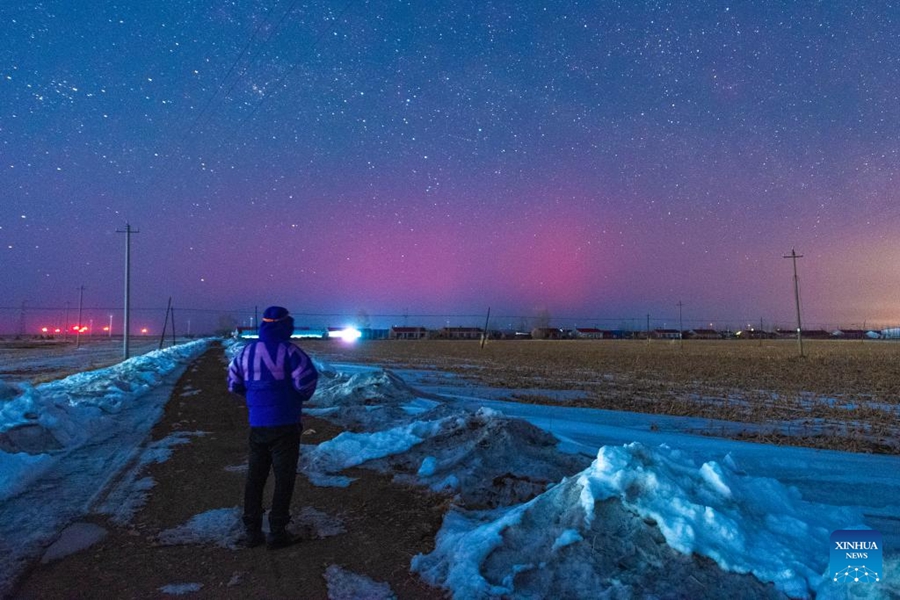 Seorang peminat fotografi melihat aurora pada waktu malam di Bandar Fujin, Jiamusi, Provinsi Heilongjiang China pada 22 Mac 2025. (Xinhua/Qu Yubao)