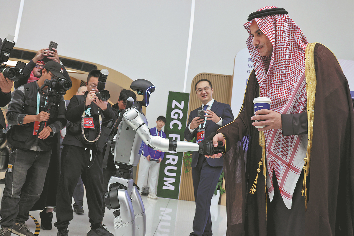 Robot sedang berjabat tangan dengan pengunjung sebelum acara pembukaan Sidang Tahunan Forum ZGC 2025. (China Daily/Wang Jing)