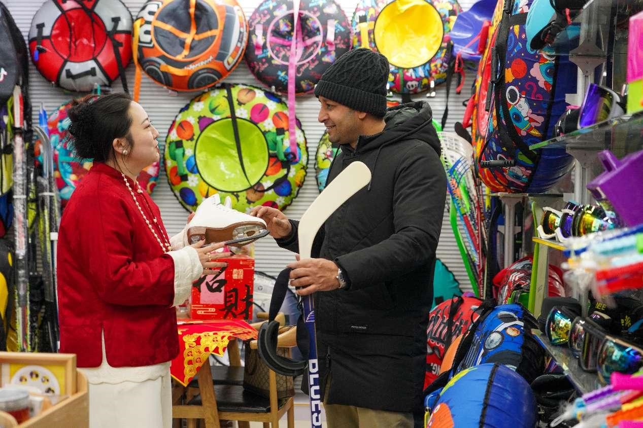 Seorang warga asing membeli peralatan sukan musim sejuk di Pasar Dagangan Antarabangsa Yiwu di Provinsi Zhejiang, timur China. (People’s Daily Online/Zhang Yongtao)