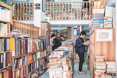 Pelanggan sedang memilih buku terpakai di kedai buku di daerah Yangpu, Shanghai. (Foto/Wang Chu)