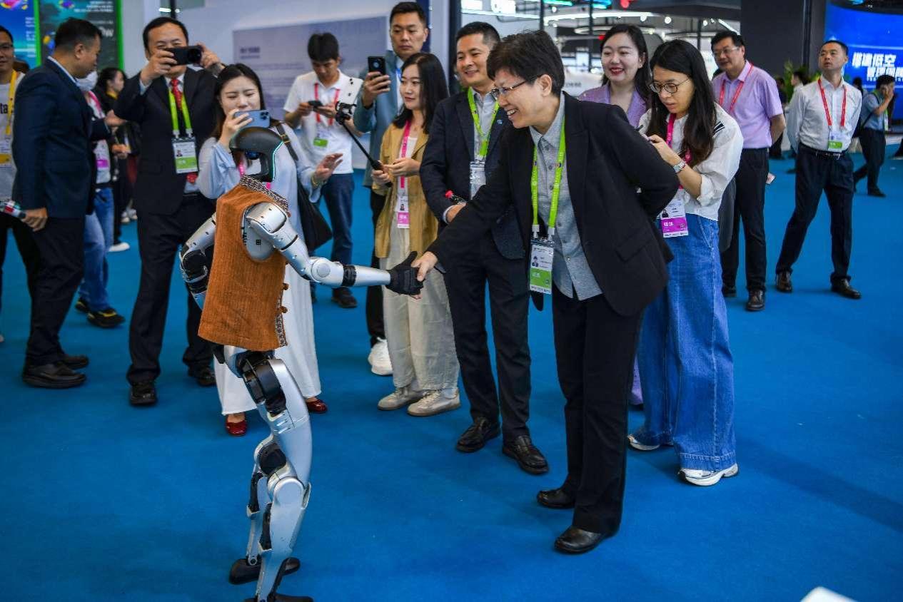 Sebuah robot yang dibangunkan oleh Unitree Robotics sedang berjabat tangan dengan pempamer di Ekspo Produk Pengguna Antarabangsa China ke-5 di Provinsi Hainan, selatan China pada 14 April 2025. (Su Bikun/People’s Daily Online)