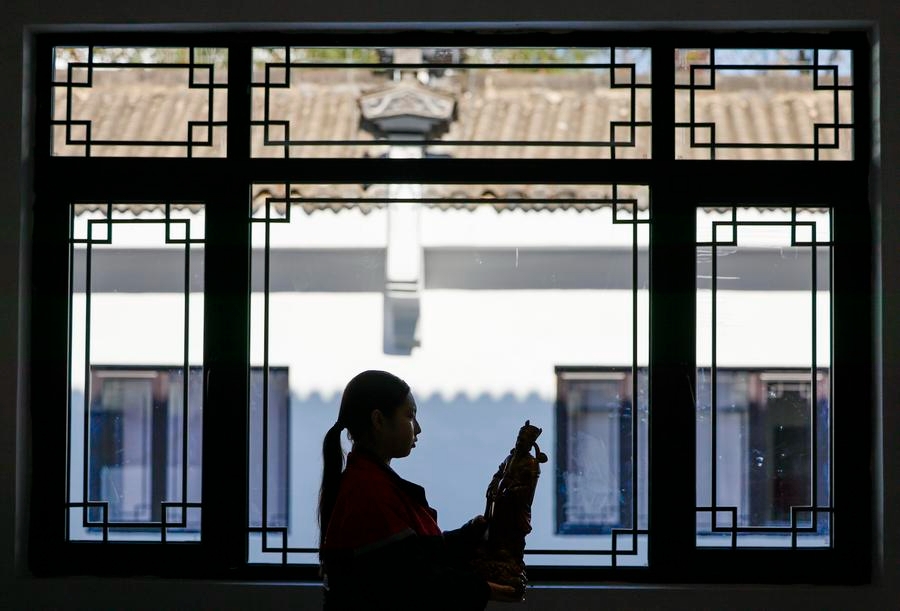 Seorang pelajar sedang meneliti satu hasil kerja ukiran kayu semasa kelas latihan amali di sebuah sekolah di Kaunti Shexian, Bandar Huangshan di Provinsi Anhui, timur China pada 27 November 2024. (Xinhua/Shi Yalei)