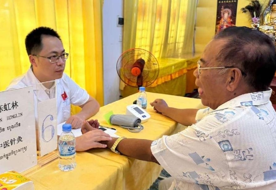 Ketua pasukan kumpulan ketiga pasukan bantuan perubatan tradisional Cina ke Kemboja menyediakan klinik percuma untuk pesakit tempatan. (Foto Li Huiying)