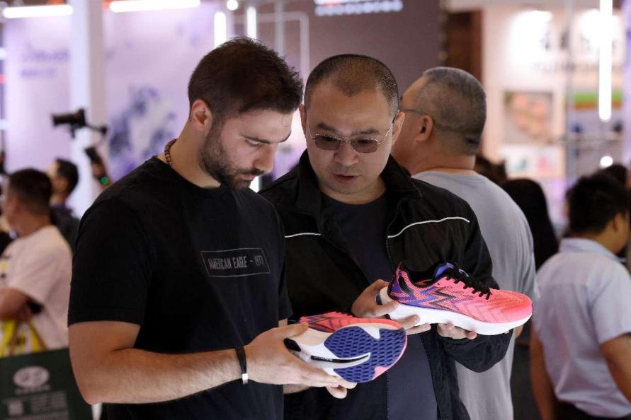 Pengunjung yang melawat Ekspo Antarabangsa Industri Sukan ke-8 dan Kasut Jinjiang ke-25 sedang mempelajari tentang teknologi kejuruteraan kasut sniker pada 19 April 2024. (People’s Daily Online/Wang Wangwang)