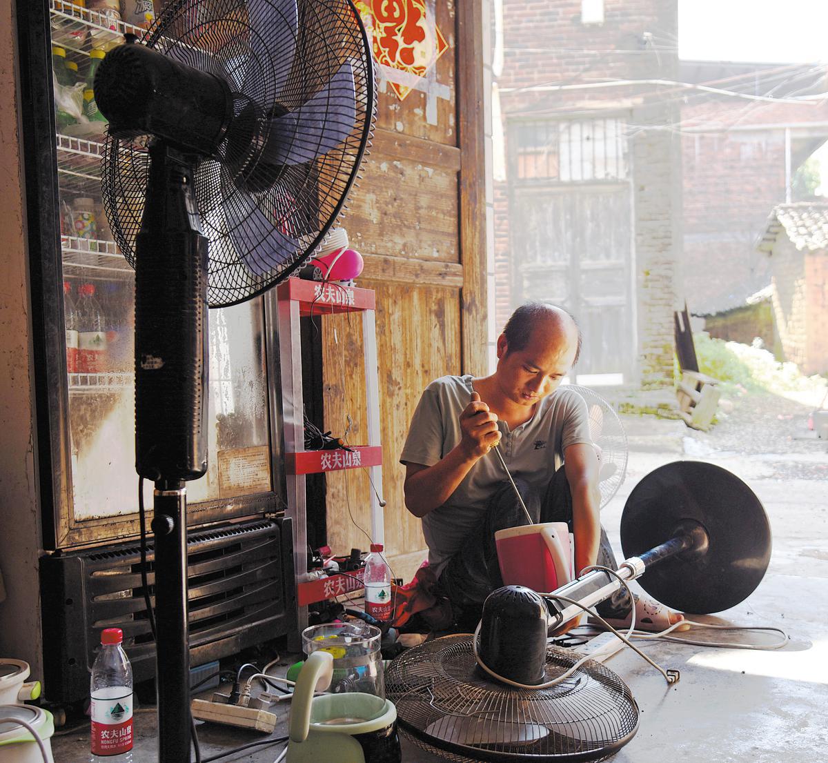 Luo Yaping sedang bekerja di kedai baik pulih perkakasan kecil miliknya di kampung Caoyuan, kaunti Qidong, Provinsi Hunan. (Foto untuk China Daily)