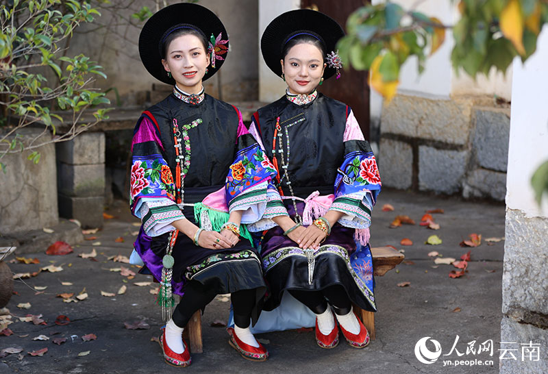 Gadis etnik Bai memakaikan pakaian pengantin perempuan. (People's Daily Online/Jiang Ze)