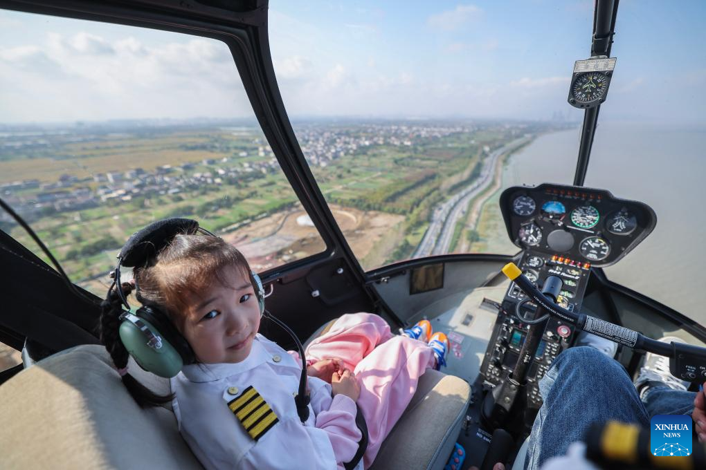 Seorang budak perempuan menaiki helikopter dari sebuah pangkalan helikopter untuk menikmati pemandangan Tasik Taihu dari udara di Huzhou, provinsi Zhejiang, timur China, 5 November 2024. (Xinhua/Xu Yu)