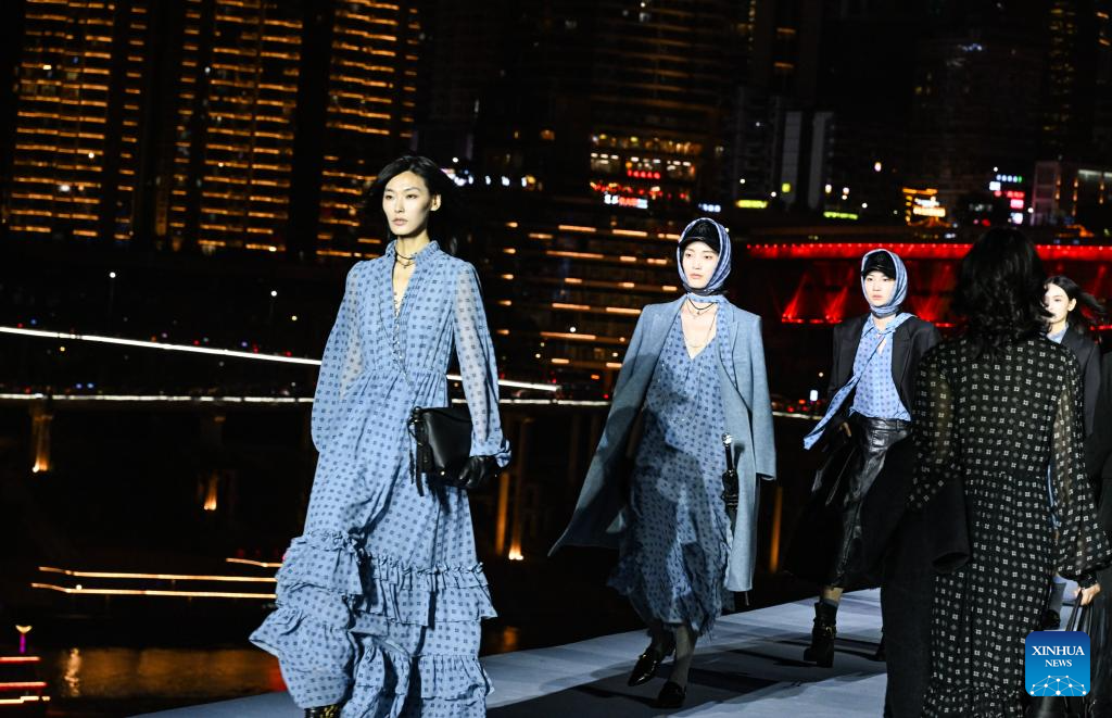 Model-model memperagakan rekaan dari koleksi musim sejuk 2025 XUEGE semasa satu pertunjukan fesyen luar di Chongqing, barat daya China, 19 Mei 2025. Pertunjukan tersebut, yang berlatarbelakangkan panorama malam bandar mega itu, menyajikan kepada para penonton satu kombinasi kreativiti fesyen dan glamor metropolitan. (Xinhua/Wang Quanchao)