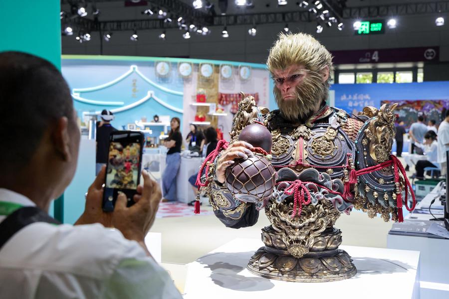 Seorang pengunjung mengambil foto bust ‘Black Myth: Wukong’ semasa berlangsungnya  Pameran Industri Kebudayaan Antarabangsa (Shenzhen) China di Provinsi Guandong, selatan China pada 23 Mei 2025. (Xinhua/Liang Xu)