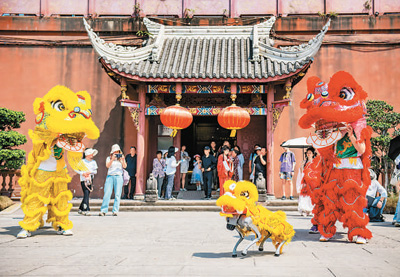 Penari tarian singa dan anjing robotik membuat persembahan di dataran di bandar purba Luodai, bandar Chengdu, Provinsi Sichuan, barat daya China, 4 Mei 2025. (Foto/Zhou Qiaomin)