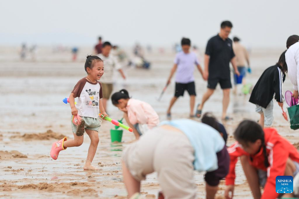 Kanak-kanak bermain riang di tepi laut sebuah peranginan di Daerah Ganyu, Bandar Lianyugang di Provinsi Jiangsu, timur China pada 1 Jun 2025. Orang ramai menikmati cuti tiga hari sempena Pesta Perahu Naga yang turut dikenali sebagai Pesta Duanwu yang jatuh pada 31 Mei pada tahun ini dengan pelbagai aktiviti di serata negara. (Xinhua/Si Wei)