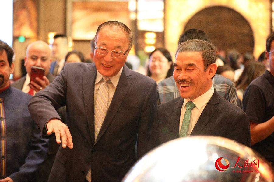 Duta Besar Brunei ke China, Pehin Dato Rahmani Basir (kanan) dan Setiausaha Agung Forum Boao untuk Asia, Zhang Jun sedang menyaksikan demonstrasi masakan Malaysia oleh cef undangan dari Malaysia. (People’s Daily Online/Wang Jing)